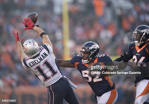 New England Patriots wide receiver Julian Edelman hauls in a pass in front of Denver Broncos defenders Corey Nelson and Darian Stewart in the first...