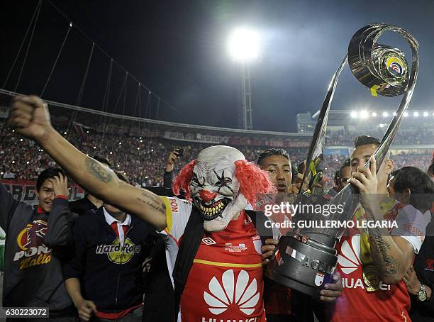 Players and supporters of Santa Fe celebrate with the trophy after winning their Colombian Football League final match against Deportes Tolima and...