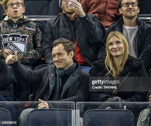 Jude Law and Philipa Coan are seen during New Jersey Devils Vs. New York Rangers at Madison Square Garden on December 18, 2016 in New York City.