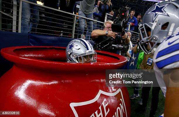 Ezekiel Elliott of the Dallas Cowboys celebrates after scoring a touchdown by jumping into a Salvation Army red kettle during the second quarter...