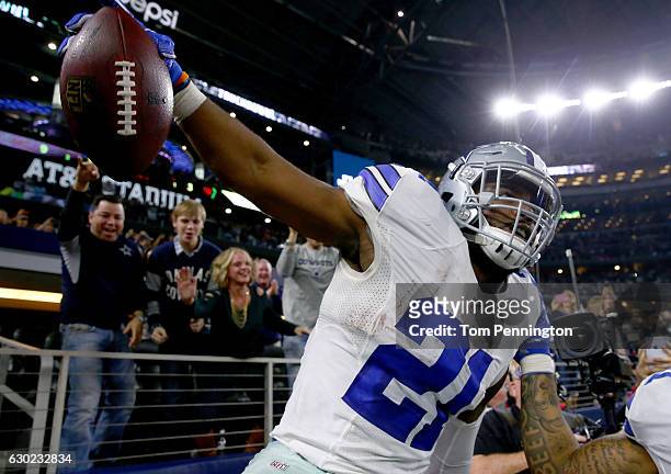 Ezekiel Elliott of the Dallas Cowboys celebrates after scoring a touchdown by jumping into a Salvation Army red kettle during the second quarter...