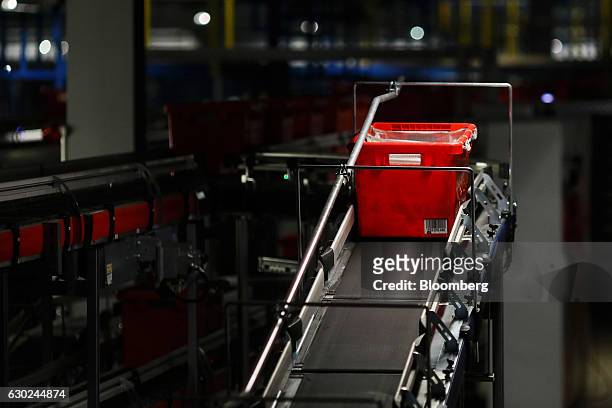 Customer order crate travels along a conveyor belt at the Ocado Group Plc distribution centre in Dordon, U.K., on Friday, Dec. 16, 2016. Ocado...