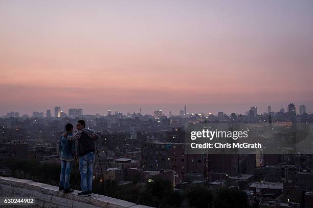 Two boys look out over the Cairo skyline at sunset on December 10, 2016 in Cairo, Egypt. Since the 2011 Arab Spring, Egyptians have been facing a...