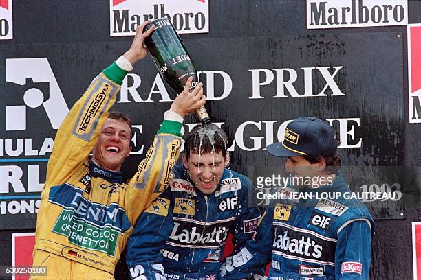 German driver Michael Schumacher who finished second, spills champagne over the winner, British driver Damon Hill as French driver Alain Prost looks...