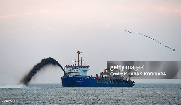 Dredger pumps sand to reclaim land just outside the port of Colombo on December 19 as part of a USD 1.4 billion real estate development by China. The...