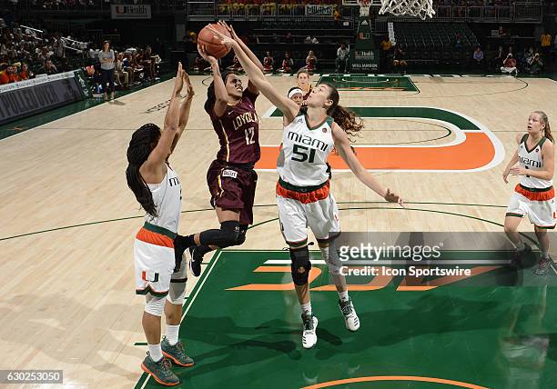 Miami center Serena-Lynn Geldof defends against the shot of Loyola guard/forward Citiana Negatu during an NCAA basketball game between Loyola Chicago...