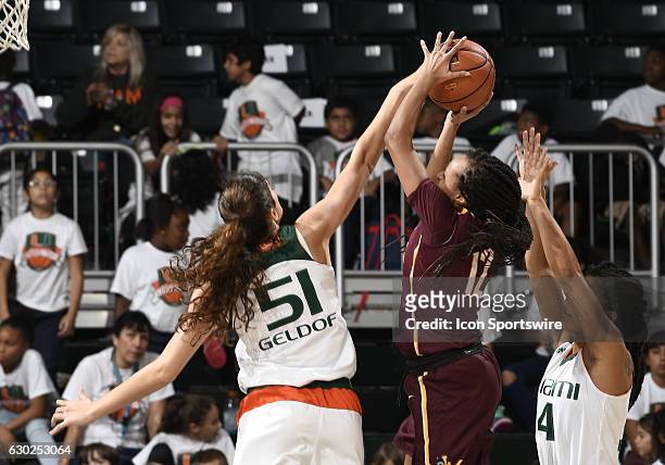 Miami center Serena-Lynn Geldof defends against the shot of Loyola guard/forward Citiana Negatu during an NCAA basketball game between Loyola Chicago...