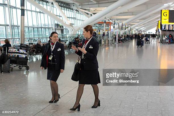 Cabin Crew, employed by British Airways, a unit of International Consolidated Airlines Group SA , walk through Terminal 5 at London Heathrow Airport,...