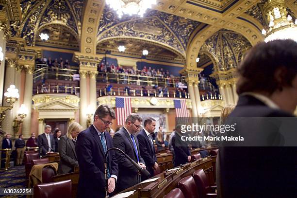 Attendees pray before electors cast their votes in the House of Representatives chamber of the Pennsylvania Capitol Building December 19, 2016 in...