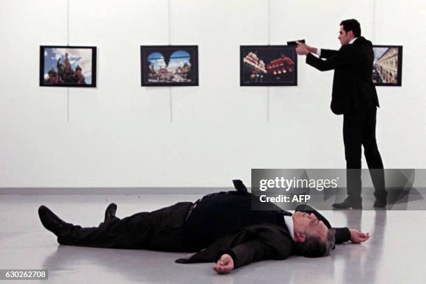 Graphic content / This picture taken on December 19, 2016 shows Andrei Karlov , the Russian ambassador to Ankara, lying on the floor after being shot...