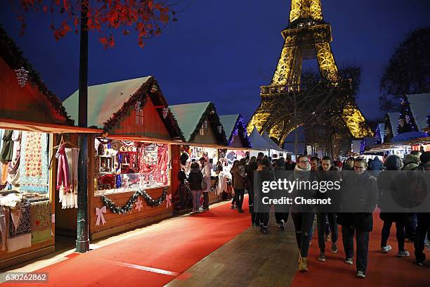 People visit the Christmas market next to the Eiffel Tower on December 19, 2016 in Paris, France. This Christmas market is located on the...