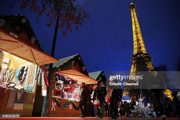 People visit the Christmas market next to the Eiffel Tower on December 19, 2016 in Paris, France. This Christmas market is located on the...