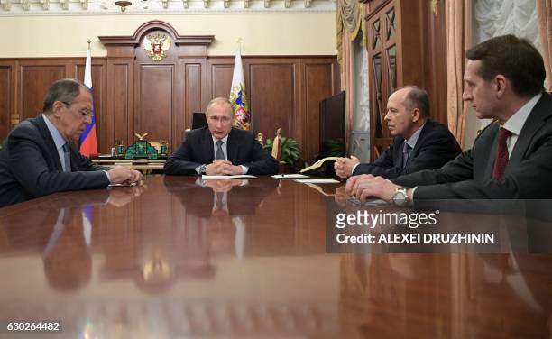 Russian President Vladimir Putin speaks with Foreign Minister Sergei Lavrov , director of the Foreign Intelligence Service Sergei Naryshkin and...