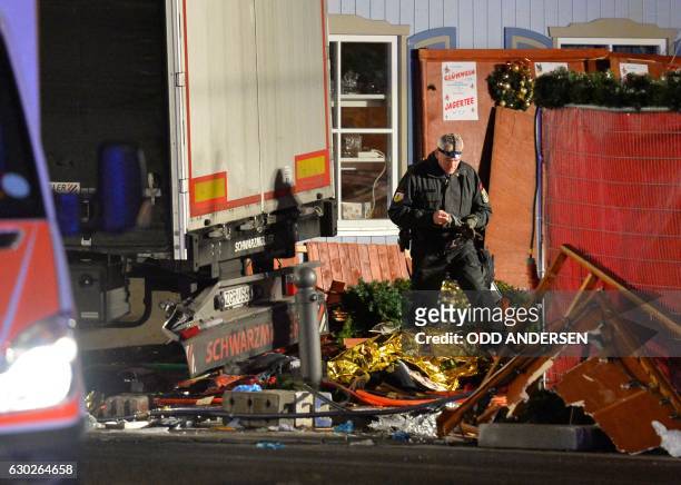 Policeman inspects the truck that crashed into a christmas market in Berlin, on December 19, 2016 killing at least one person and injuring at least...