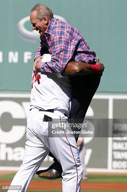 Boston Red Sox David Ortiz lifts outgoing Red Sox President Larry Lucchino after Lucchino threw out the ceremonial first pitch before the start of a...