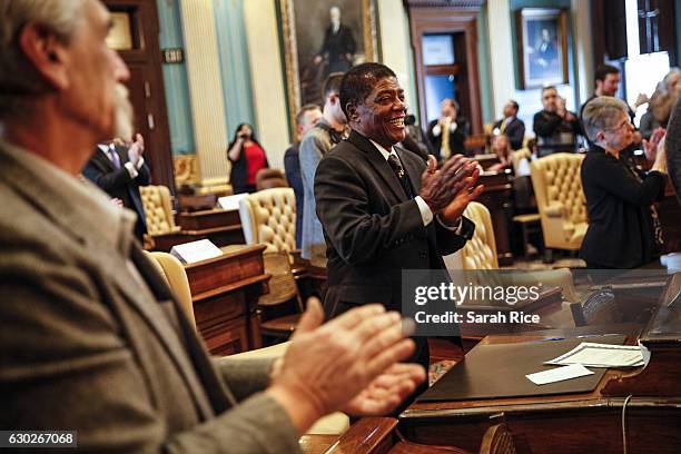 Henry Hatter, a Michigan representative to the electoral college, applauds after turning in his signed vote for President-elect Donald Trump at the...