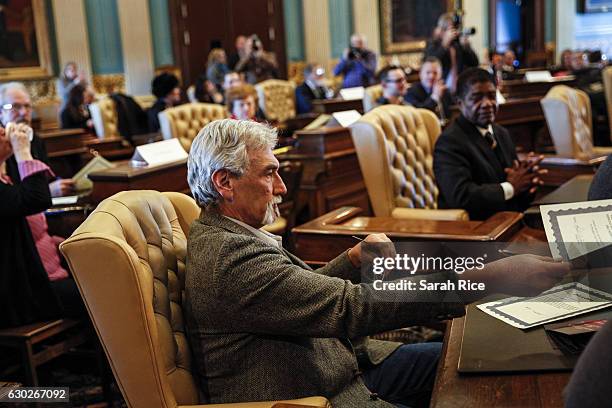 Robert Weitt, a Michigan representative to the electoral college, hands in his signed vote for President-elect Donald Trump at the Michigan State...