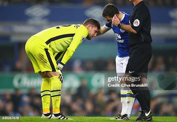 Injured goalkeeper Maarten Stekelenburg of Everton is spoken to by team mate Leighton Baines during the Premier League match between Everton and...
