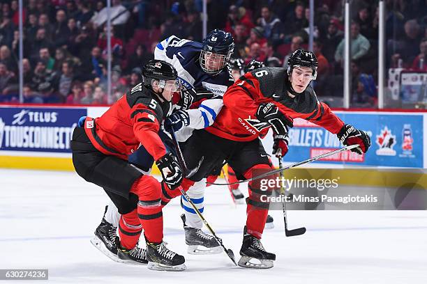 Kristian Vesalainen of Team Finland tries to squeeze through Thomas Chabot and Philippe Myers of Team Canada during the IIHF exhibition game at the...
