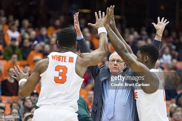 Head coach Jim Boeheim of the Syracuse Orange raises his hands alongside Syracuse Orange players as they defend during the first half against the...