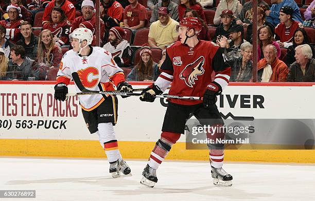 Michael Stone of the Arizona Coyotes and Matthew Tkachuk of the Calgary Flames skate during the first period at Gila River Arena on December 19, 2016...