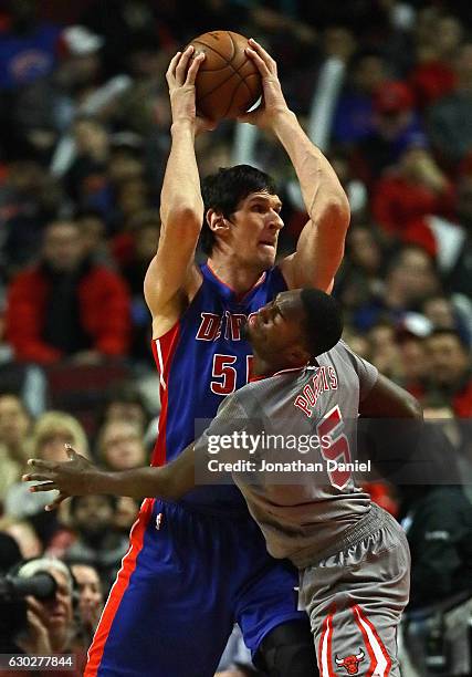 Boban Marjanovic of the Detroit Pistons looks to pass over Bobby Portis of the Chicago Bulls at the United Center on December 19, 2016 in Chicago,...