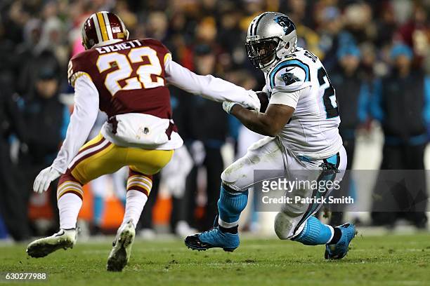 Running back Jonathan Stewart of the Carolina Panthers carries the ball against cornerback Deshazor Everett of the Washington Redskins in the first...