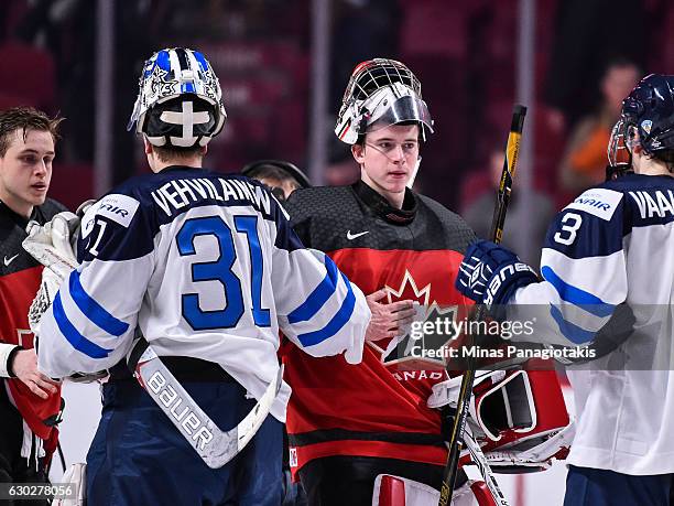 Goaltender Veini Vehvilainen of Team Finland congratulates goaltender Carter Hart of Team Canada during the IIHF exhibition game at the Bell Centre...