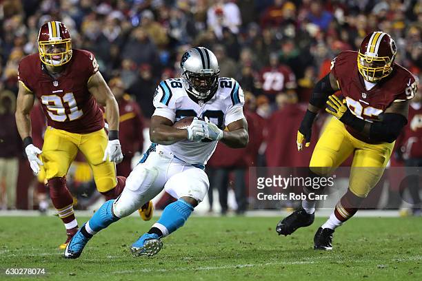 Running back Jonathan Stewart of the Carolina Panthers carries the ball against outside linebacker Ryan Kerrigan and defensive end Chris Baker of the...