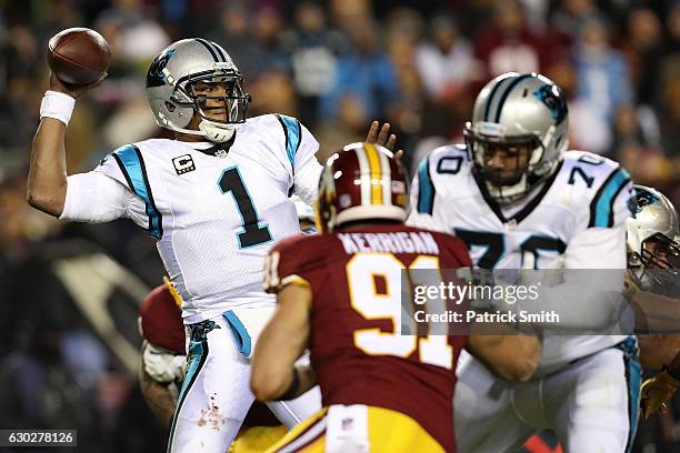 Quarterback Cam Newton of the Carolina Panthers passes the ball while teammate guard Trai Turner blocks against outside linebacker Ryan Kerrigan of...