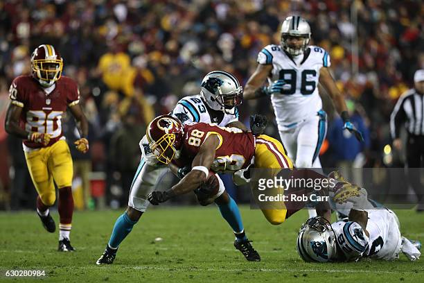 Wide receiver Pierre Garcon of the Washington Redskins is tackled by defensive back Leonard Johnson of the Carolina Panthers in the third quarter at...