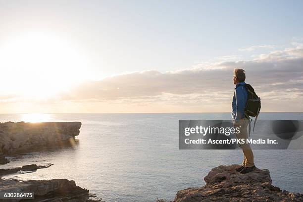 hiker stands on promontory, looks towards sunrise - cyprus stock pictures, royalty-free photos & images