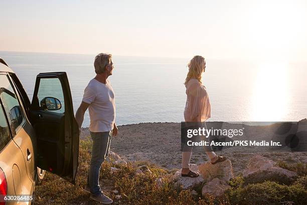 couple leave vehicle, walk out to sea view - 50s car stock pictures, royalty-free photos & images