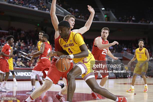 Chimezie Metu of the USC Trojans handles the ball against Stone Gettings of the Cornell Big Red during a NCAA college basketball game at Galen Center...