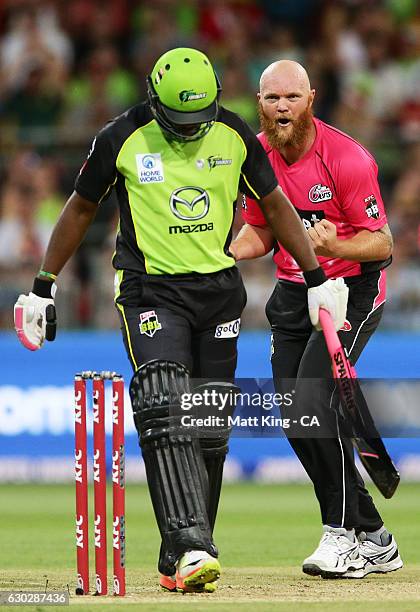 Doug Bollinger of the Sixers celebrates taking the wicket of Andre Russell of the Thunder during the Big Bash League match between the Sydney Thunder...