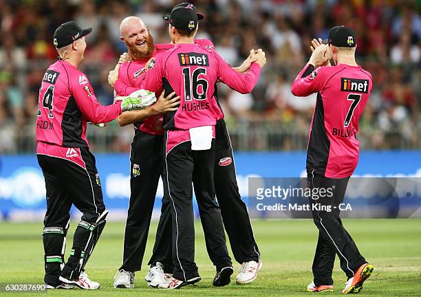 Doug Bollinger of the Sixers celebrates with team mates after taking the wicket of Chris Green of the Thunder during the Big Bash League match...