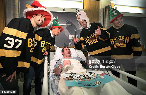 Boston Bruins players Patrice Bergeron, Brad Marchand, Colin Miller and Frank Vatrano pose with Matt Hughes at the Floating Hospital at Tufts Medical...