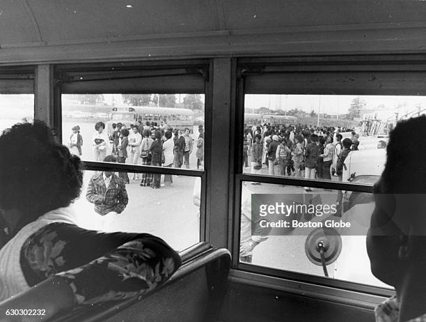Seen from inside a school bus looking out, black students wait for buses for Roxbury on Sept. 18 during the first full week of school under the new...