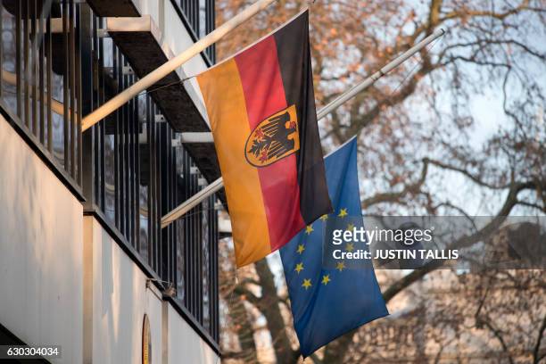 The German and EU flag fly at half-mast outside the German embassy in London on December 20, 2016 as a mark of respect following the deadly lorry...