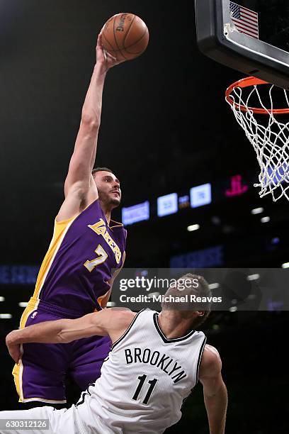 Larry Nance Jr. #7 of the Los Angeles Lakers slams home a dunk over Brook Lopez of the Brooklyn Nets in the second half at Barclays Center on...