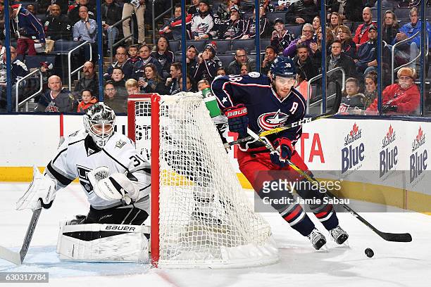 Goaltender Peter Budaj of the Los Angeles Kings defends the net as Boone Jenner of the Columbus Blue Jackets skates with the puck during the first...