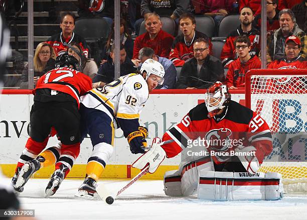 Ben Lovejoy and Cory Schneider of the New Jersey Devils defend against Ryan Johansen of the Nashville Predators during the first period at the...