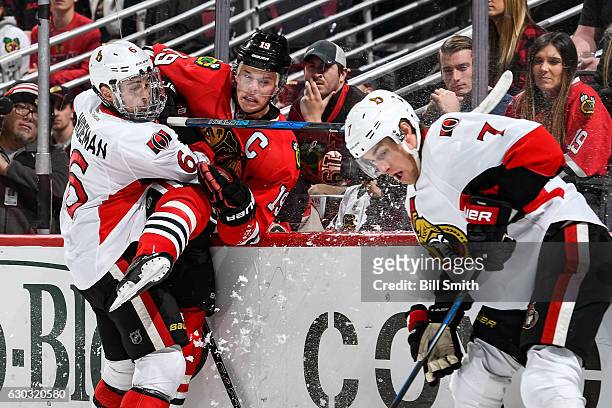 Chris Wideman of the Ottawa Senators checks Jonathan Toews of the Chicago Blackhawks into the glass, as Kyle Turris watches the puck, in the first...