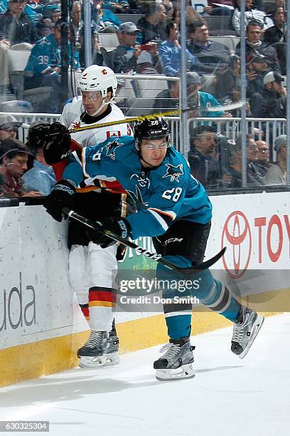 Timo Meier of the San Jose Sharks hits Jyrki Jokipakka of the Calgary Flames during a NHL game at SAP Center at San Jose on December 20, 2016 in San...