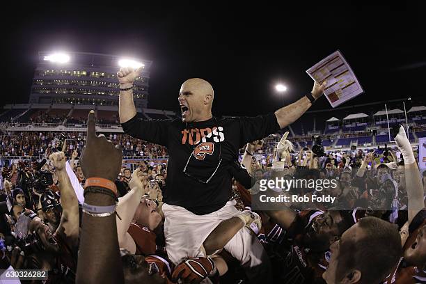 Interm head coach Nick Holt of the Western Kentucky Hilltoppers is lifted onto his players' shoulders following the game against the Memphis Tigers...