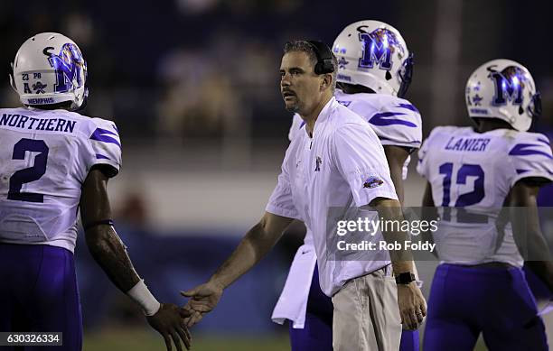 Head coach Mike Norvell of the Memphis Tigers slaps hands with players during the fourth quarter of the game against the Western Kentucky Hilltoppers...