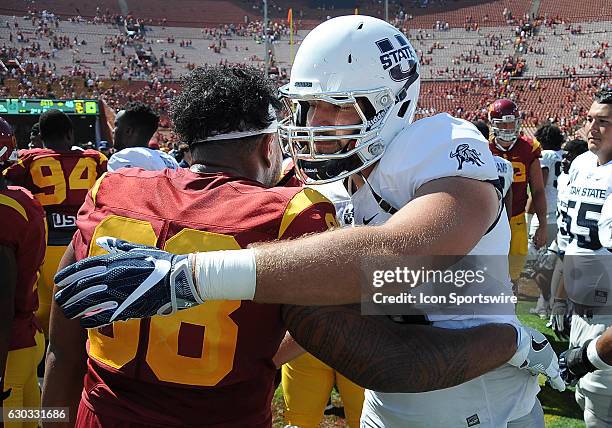 Utah State Aggies offensive lineman Cody Boyer with USC Trojans defensive tackle Josh Fatu after the Trojans defeated the Aggies 45 to 7 in a game...