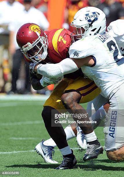 Trojans wide receiver Deontay Burnett is tackled by Utah State Aggies safety Dalin Leavitt in the first quarter of a game against the played at the...