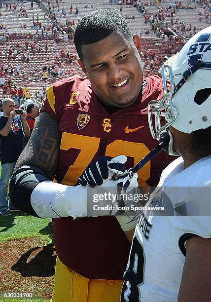 Trojans defensive tackle Zach Banner on the field with Utah State Aggies offensive lineman Dalton Forsyth after the Trojans defeated the Aggies 45 to...