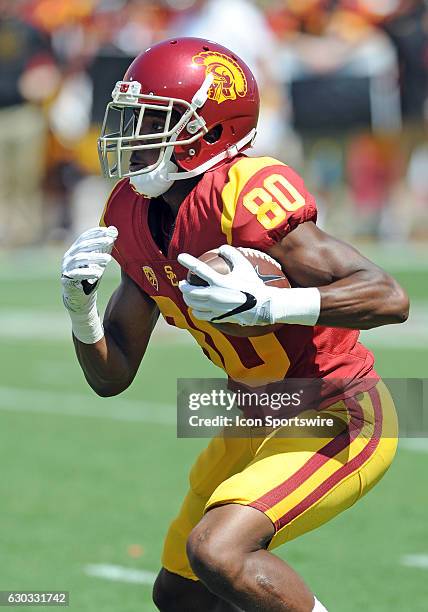 Trojans wide receiver Deontay Burnett catches a pass and runs in for a touchdown during the second quarter of a game against the Utah State Aggies...